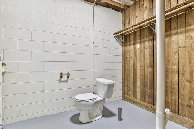 bathroom featuring wood walls and toilet