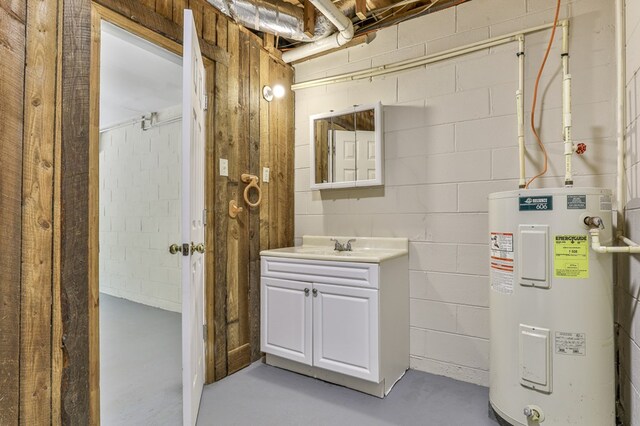 bathroom with concrete floors, electric water heater, and vanity