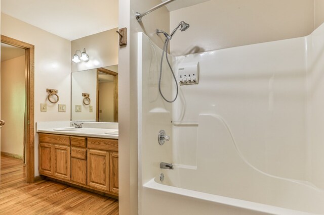 bathroom featuring vanity, shower / bath combination, and wood-type flooring