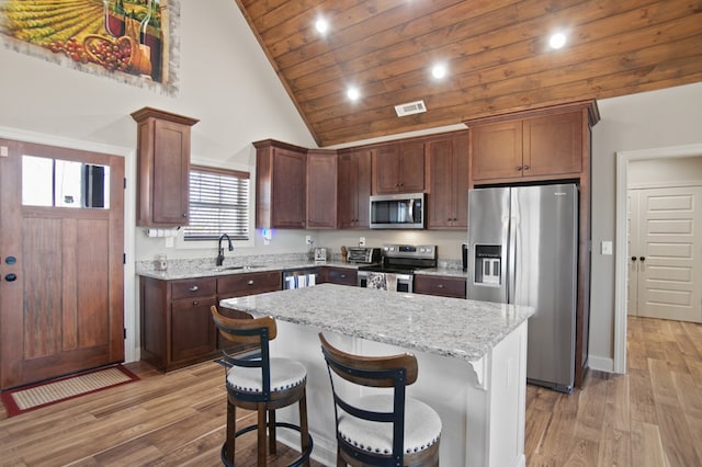 kitchen with appliances with stainless steel finishes, a sink, visible vents, and light wood-style floors