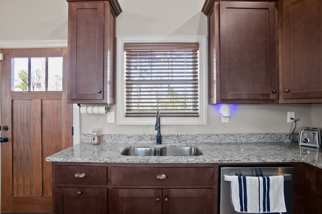 kitchen featuring dishwashing machine, light stone counters, plenty of natural light, and a sink