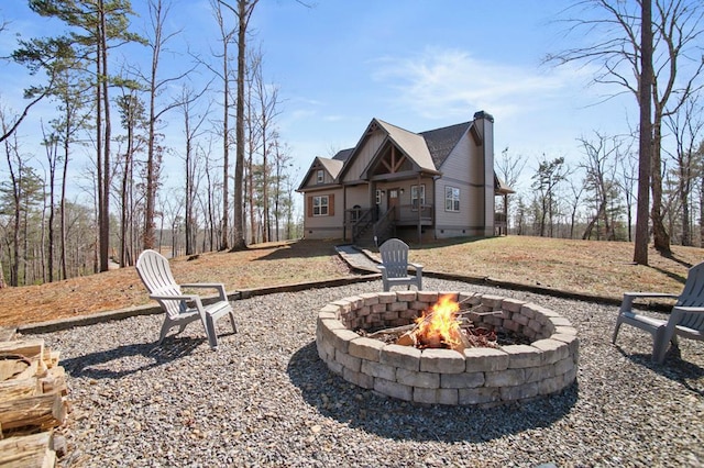 back of house with crawl space, an outdoor fire pit, and a chimney