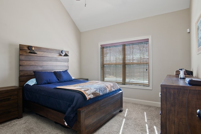 bedroom with light colored carpet, vaulted ceiling, and baseboards