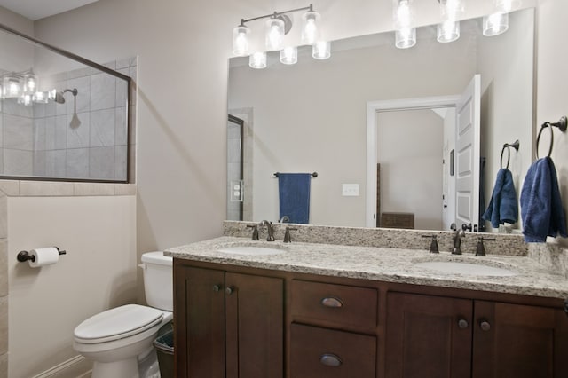 full bathroom with tiled shower, a sink, toilet, and double vanity