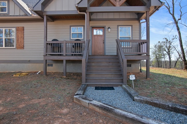 property entrance with board and batten siding and crawl space