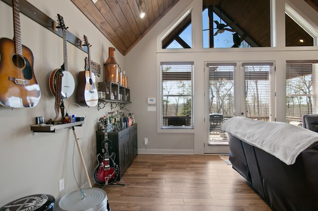 doorway to outside featuring plenty of natural light, vaulted ceiling, ceiling fan, and wood finished floors