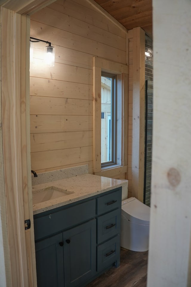 bathroom featuring toilet, wooden ceiling, vanity, wooden walls, and hardwood / wood-style flooring