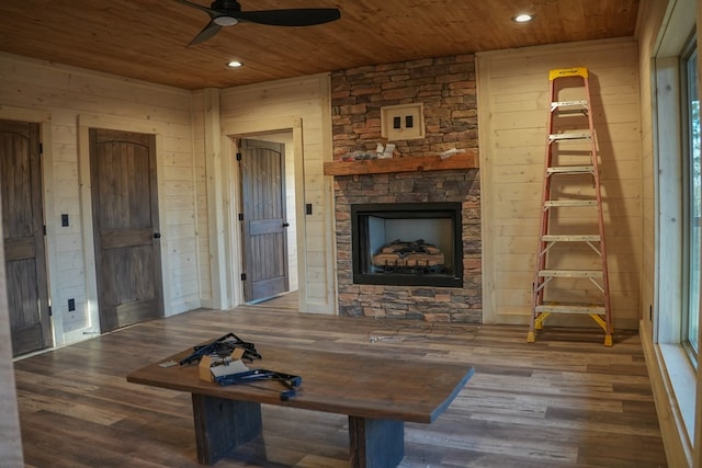 living room with hardwood / wood-style flooring, wooden ceiling, wooden walls, and a fireplace