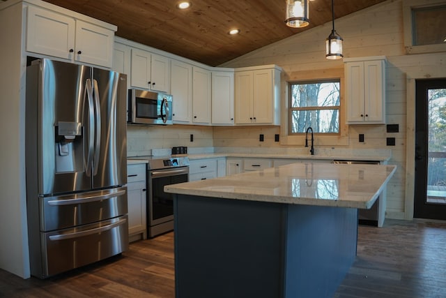 kitchen featuring a kitchen island, lofted ceiling, white cabinets, hanging light fixtures, and stainless steel appliances