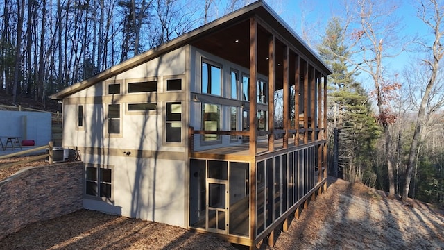 view of side of property featuring a sunroom and central AC unit