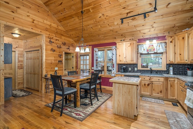 kitchen featuring light brown cabinetry, light wood-type flooring, pendant lighting, a kitchen island, and sink