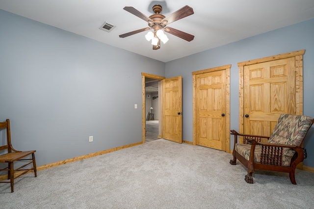 living area featuring ceiling fan and carpet flooring