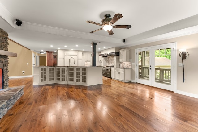 802 Old Mill Trl, Ball Ground, GA 30107 - unfurnished living room featuring crown molding, ceiling fan, a sink, a stone fireplace, and wood finished floors