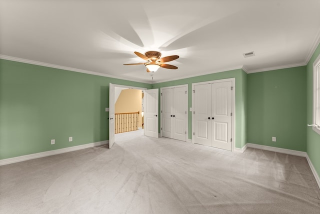 802 Old Mill Trl, Ball Ground, GA 30107 - unfurnished bedroom featuring multiple closets, light carpet, ornamental molding, baseboards, and ceiling fan