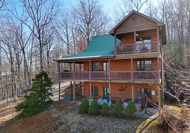 exterior space featuring a patio, metal roof, and log veneer siding