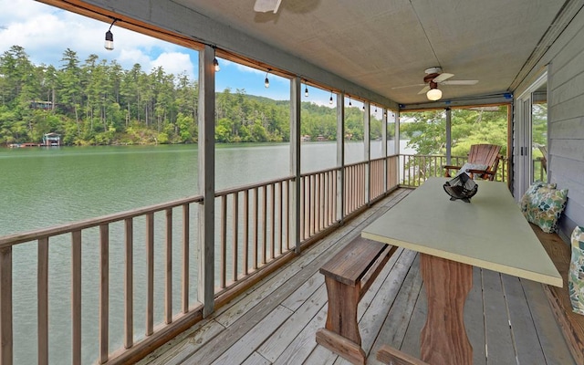 unfurnished sunroom featuring a water view and ceiling fan