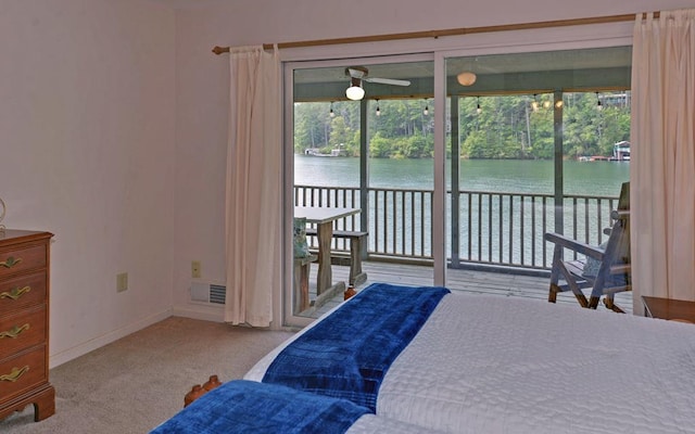 carpeted bedroom featuring multiple windows, access to exterior, and a water view