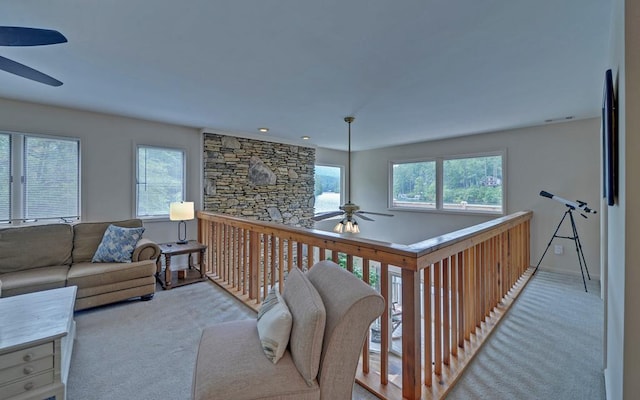 interior space featuring a healthy amount of sunlight, ceiling fan, and light colored carpet