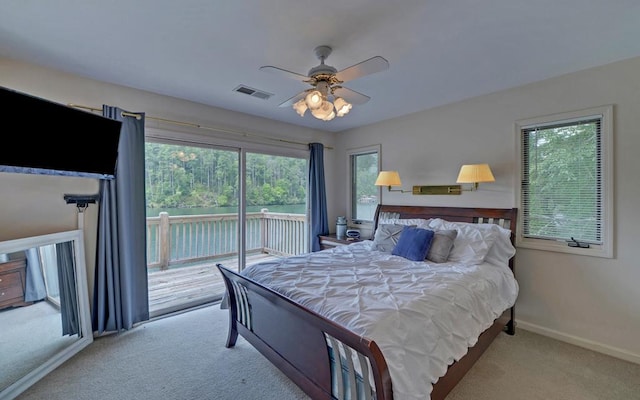 bedroom with light carpet, multiple windows, access to exterior, and ceiling fan