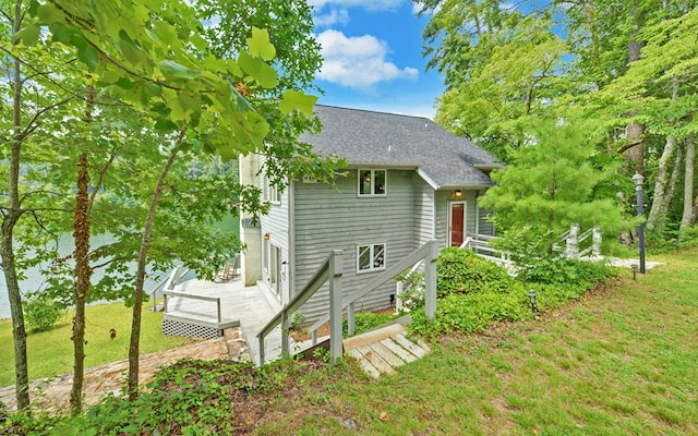 rear view of house with a deck and a yard