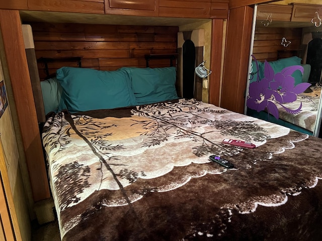 bedroom with wooden walls and a closet