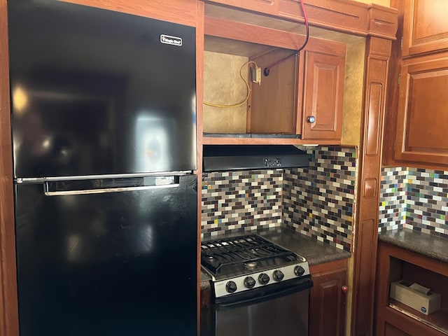 kitchen with black fridge, gas range, and decorative backsplash