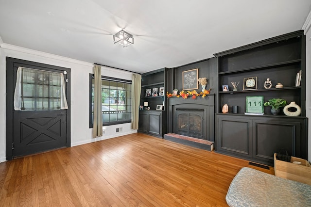 interior space with light hardwood / wood-style flooring and crown molding