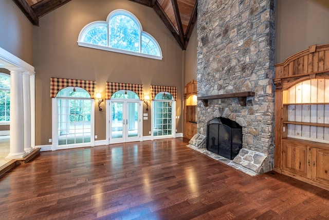 unfurnished living room with beam ceiling, french doors, high vaulted ceiling, hardwood / wood-style floors, and a fireplace