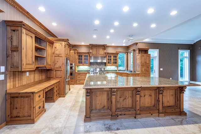 kitchen featuring appliances with stainless steel finishes, tasteful backsplash, crown molding, and a spacious island