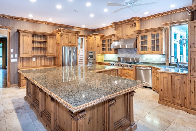 kitchen with a wealth of natural light, a large island, stainless steel appliances, and ornamental molding