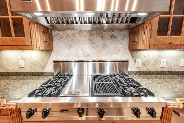 kitchen with stainless steel gas stovetop, wall chimney exhaust hood, and decorative backsplash