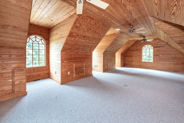 additional living space featuring ceiling fan, wooden ceiling, wood walls, vaulted ceiling, and carpet