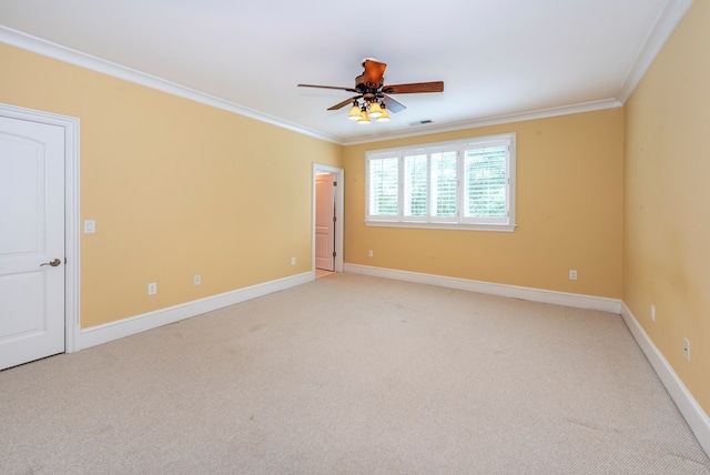 spare room with ceiling fan, light colored carpet, and crown molding