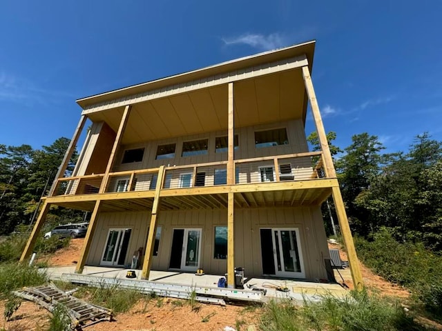 back of property with a balcony and a patio