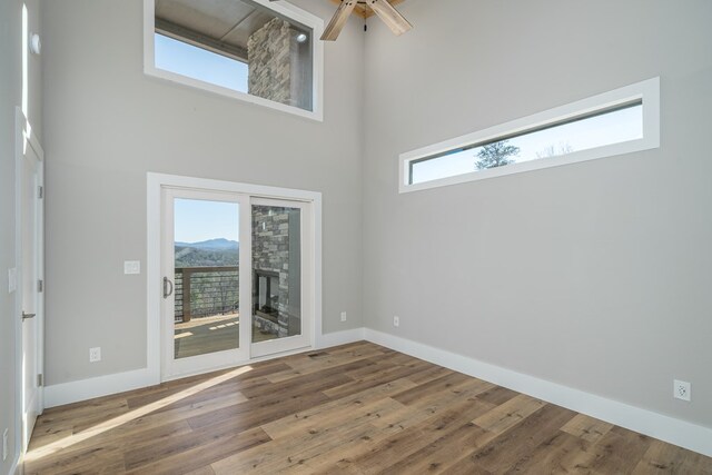 538 Mountain Laurel Rdg, Mineral Bluff, GA 30559 - empty room featuring a towering ceiling, a ceiling fan, wood finished floors, and baseboards