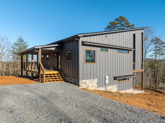 538 Mountain Laurel Rdg, Mineral Bluff, GA 30559 - view of front of house with board and batten siding, a deck, and stone siding