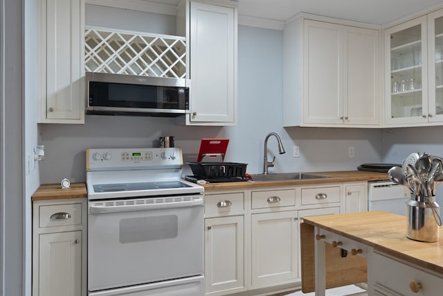 kitchen featuring white electric range, butcher block countertops, sink, and white cabinets