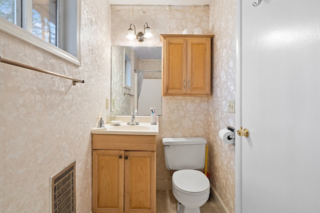 bathroom with vanity, heating unit, and toilet