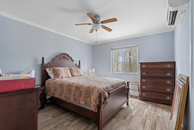 bedroom featuring ornamental molding, a wall unit AC, hardwood / wood-style floors, and ceiling fan