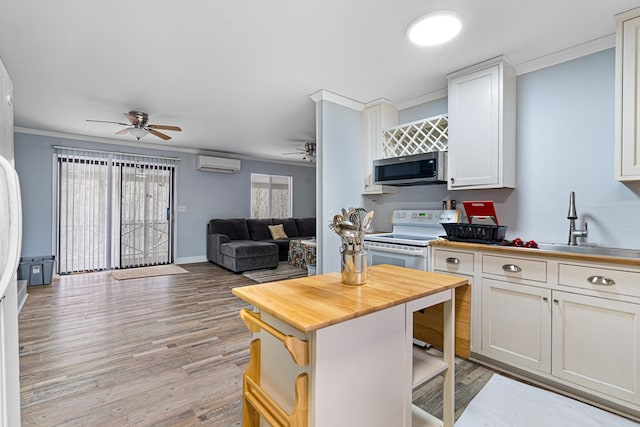 kitchen featuring white cabinetry, a wall mounted AC, ceiling fan, white range with electric cooktop, and crown molding