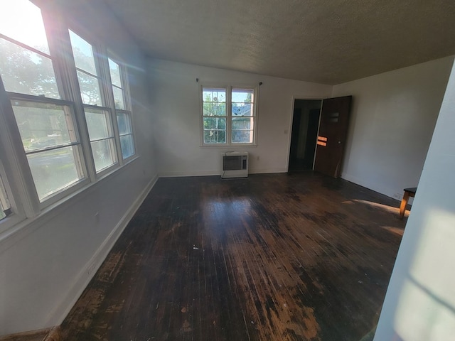 unfurnished room featuring dark wood-type flooring and a textured ceiling