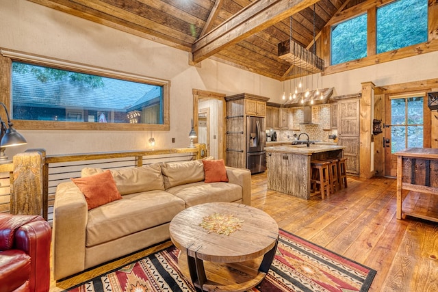 living room with beam ceiling, wooden ceiling, high vaulted ceiling, light wood finished floors, and a notable chandelier