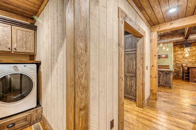 washroom with washer / dryer, wood ceiling, light wood-style flooring, and cabinet space