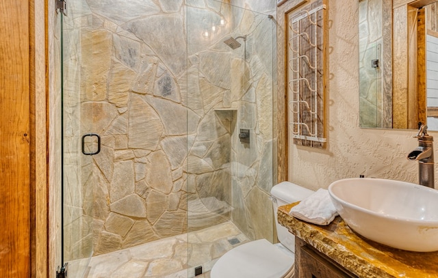 full bath with vanity, a shower stall, and toilet