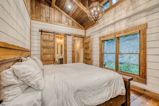 bedroom with wood walls, a barn door, wood ceiling, hardwood / wood-style flooring, and a notable chandelier