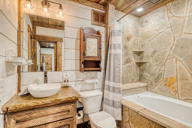 full bath with visible vents, tile walls, vanity, tiled shower / bath, and toilet