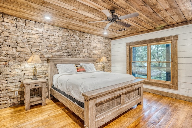bedroom featuring light wood-style floors, wood walls, and wooden ceiling