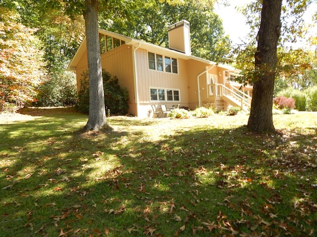 view of side of home with a yard