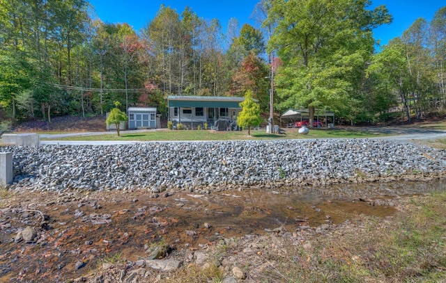 view of front of home with a wooded view