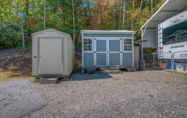 view of shed featuring fence